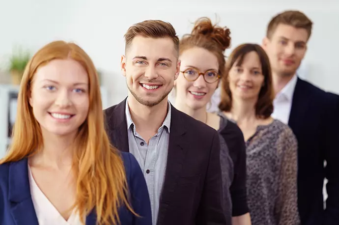 5 Studenten stehen leicht versetzt hintereinander und lächeln in die Kamera.